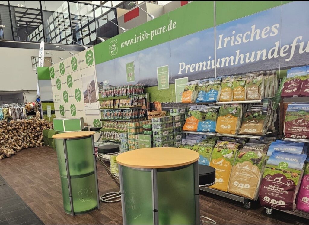 Der grüne Irish-Pure-Messestand mit Futterregalen, Dosen, Snacks und Kauknochen